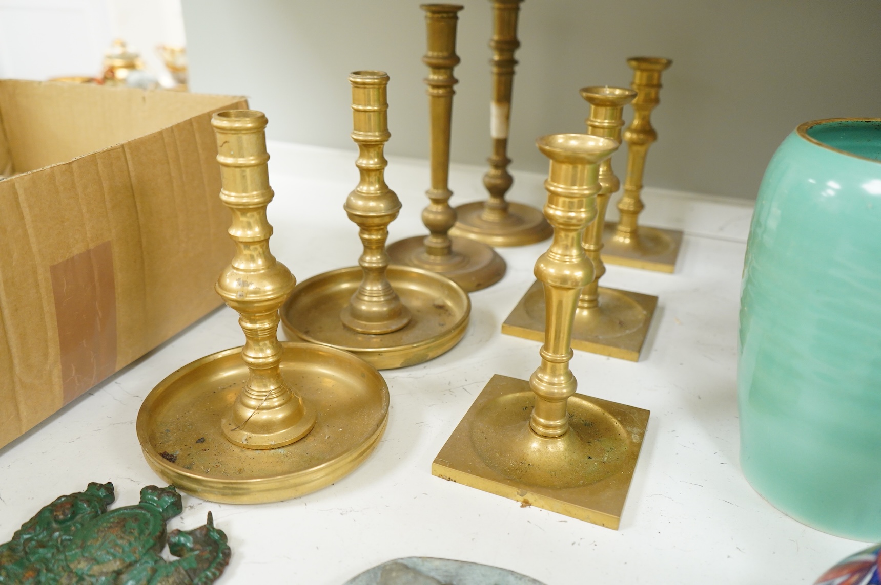 Two fire marks and a collection of brass candlesticks, tallest 25.5cm